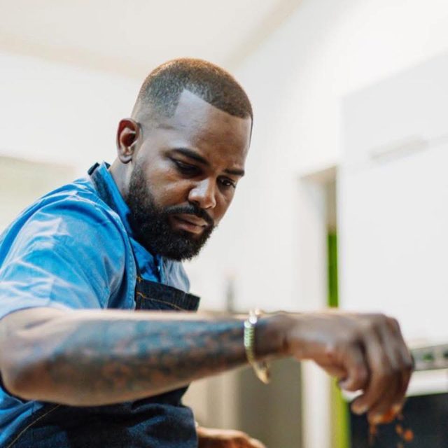 Chef Moisés Carvajal working in a bright kitchen, forearm tattooed