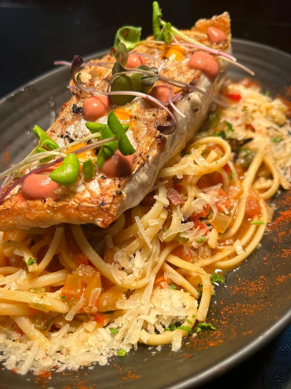 Seared fish over linguine with tomato, parmesan and micro greens